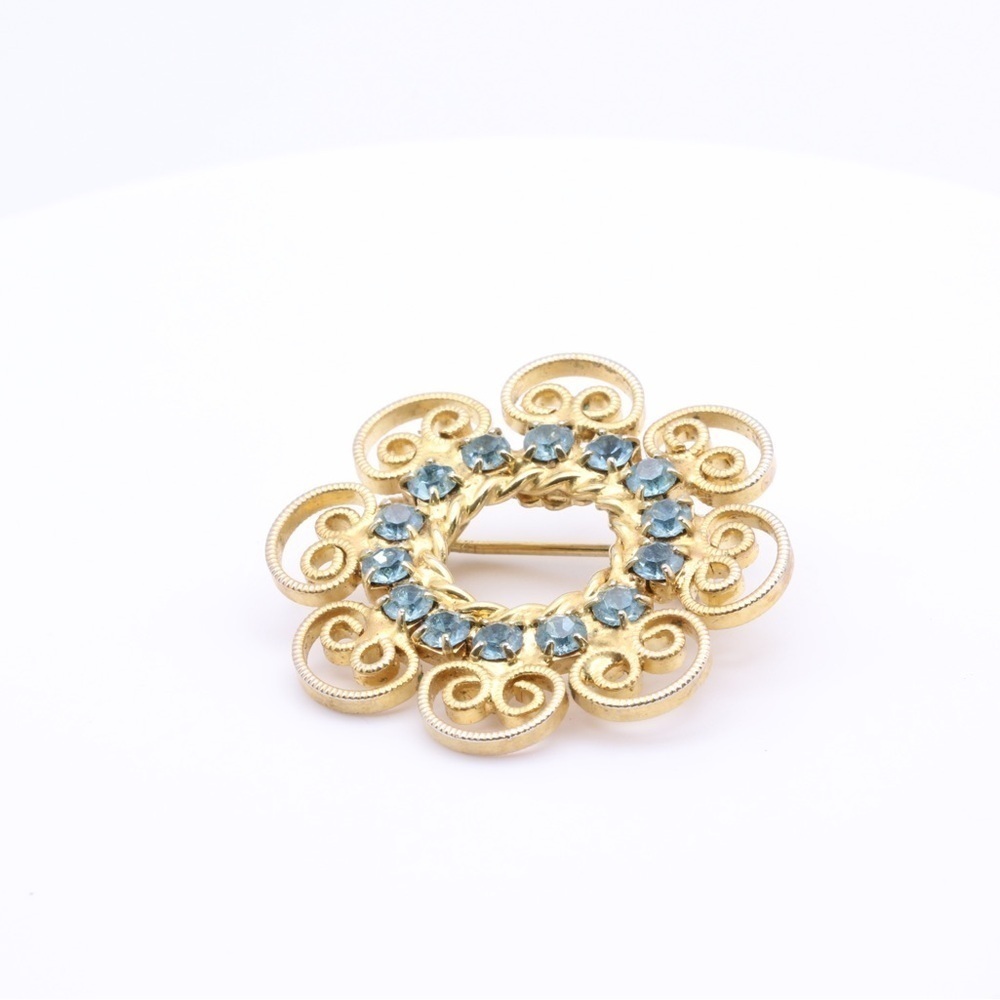 Blue Rhinestones in a gold colored filigree vintage brooch.